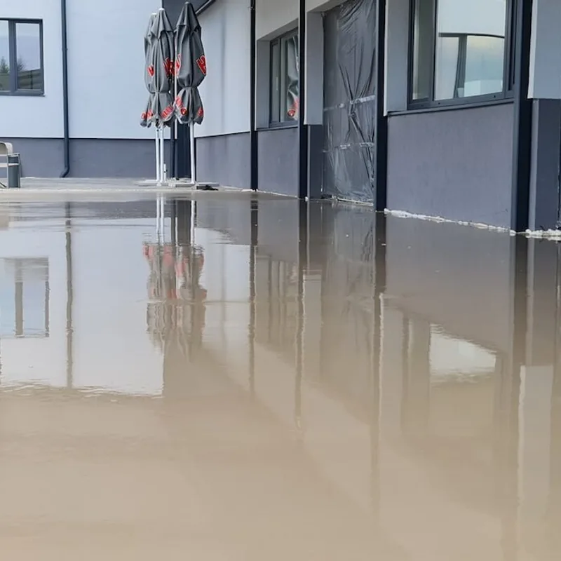 Frissen öntött, tükörsima önterülő padló egy fedett terasz alatt